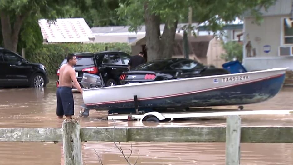 Un residente de Richmond trata de sacar algunas de sus pertenencias más necesarias en un bote.