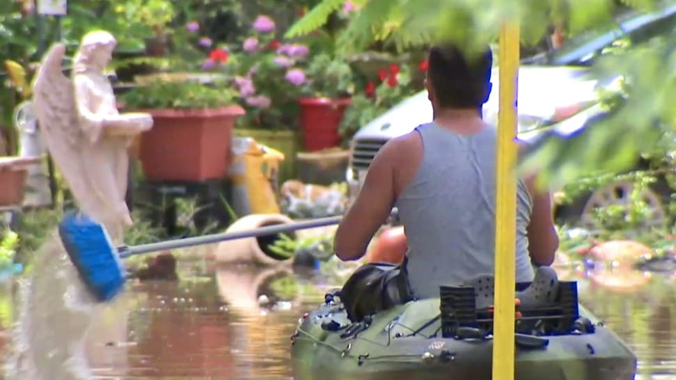 Remando con una escoba. Los residentes de las áreas afectadas han tenido que usar su ingenio para entrar y salir de sus propiedades, cuyos accesos están bloqueados por la acumulación de agua.