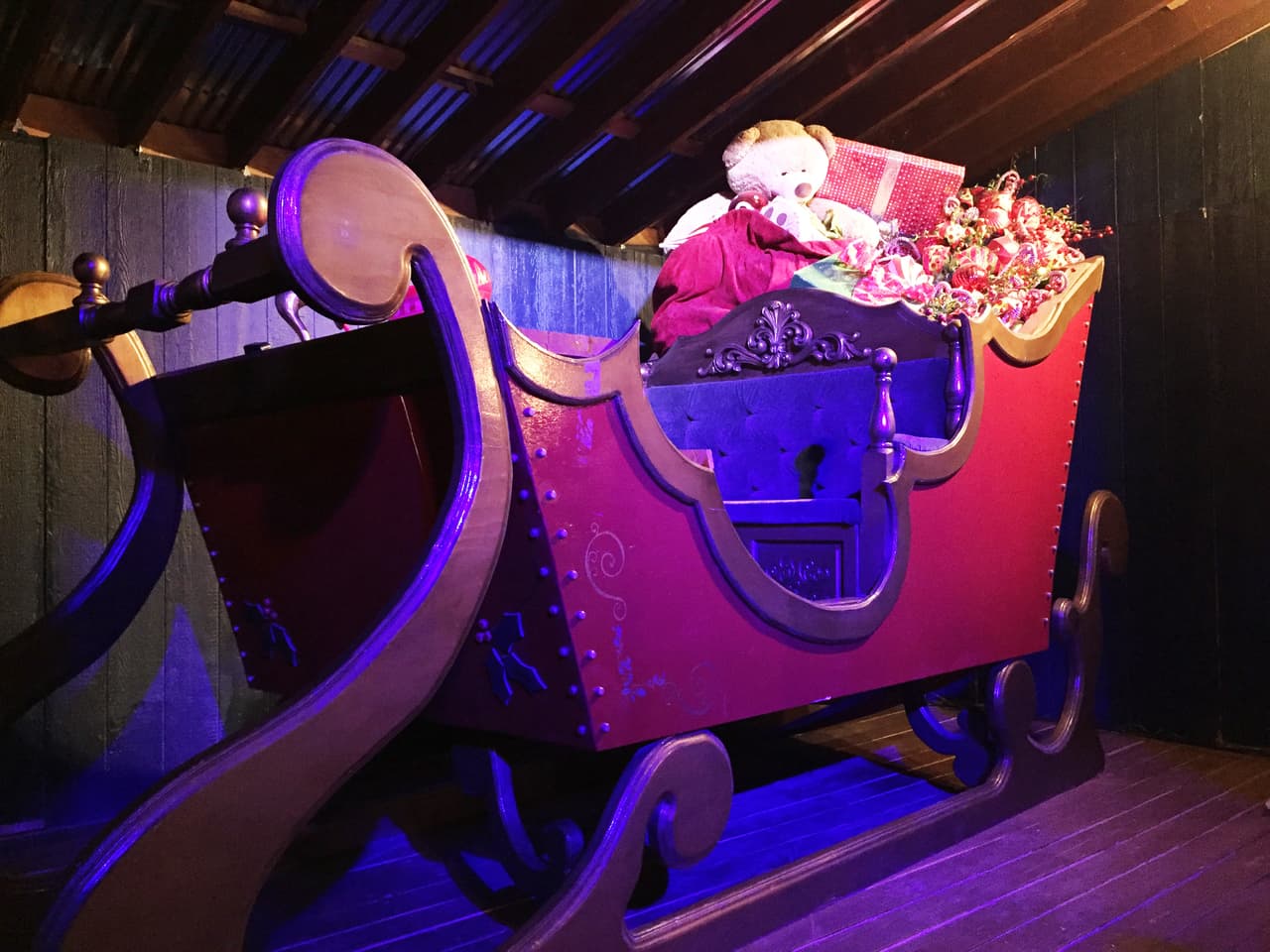 El trineo de Santa Claus cargado de regalos esta en ubicado en un cuarto.