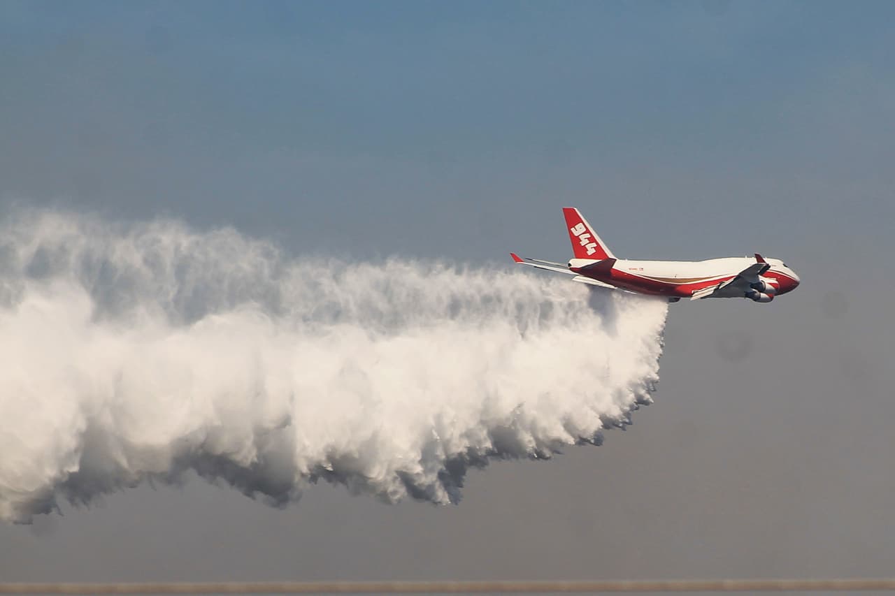 Un avión Supertanker, la aeronave cisterna más grande del mundo, descarga agua sobre el incendio forestal situado en la localidad de Hualañé, Región del Maule, Chile.