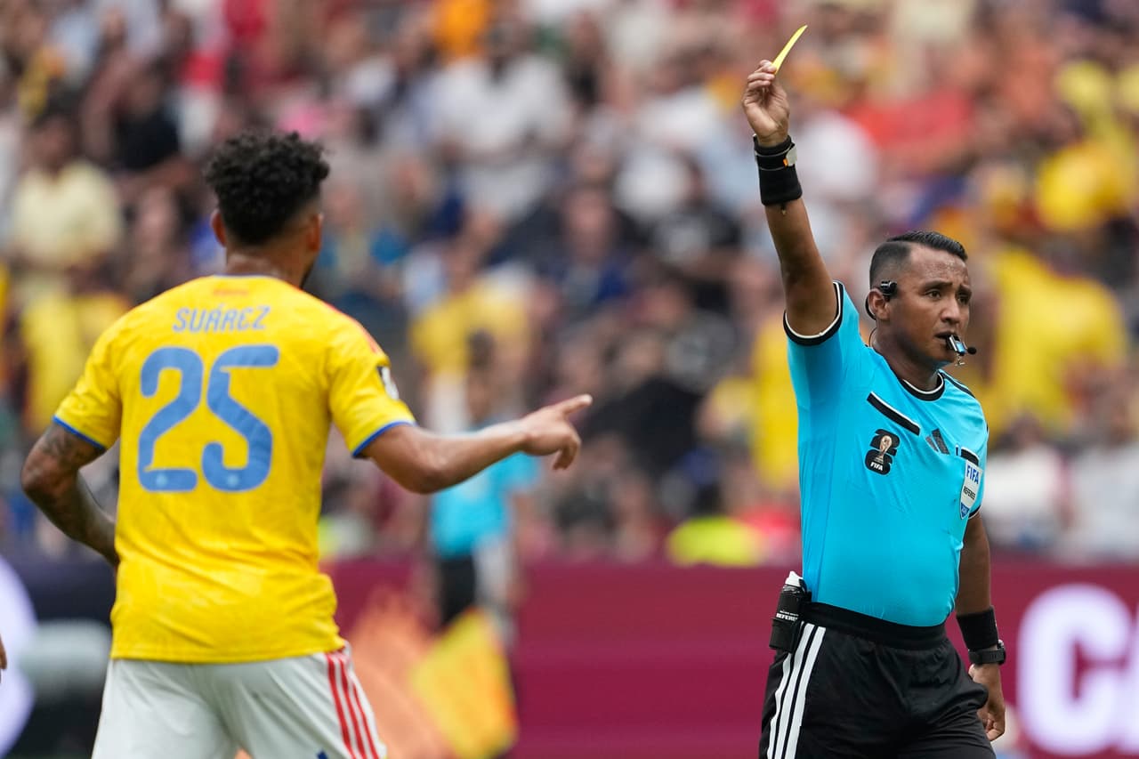 El árbitro salvadoreño Ivan Arcides Barton Cisneros (a la derecha) muestra una tarjeta amarilla al colombiano Luis Suárez durante el partido de octavos de final de la Copa del Mundo entre Suiza y Colombia en Vancouver, Columbia Británica, el martes 7 de julio de 2026.