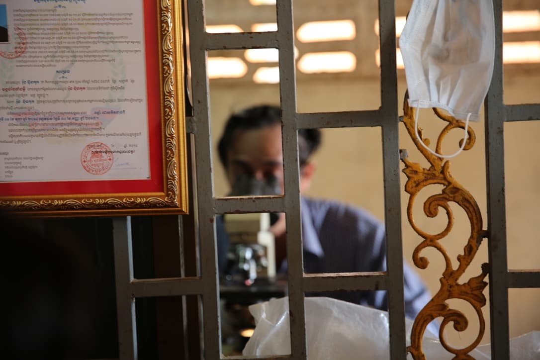 After taking out some blood, the doctor carefully observes it under the microscope.