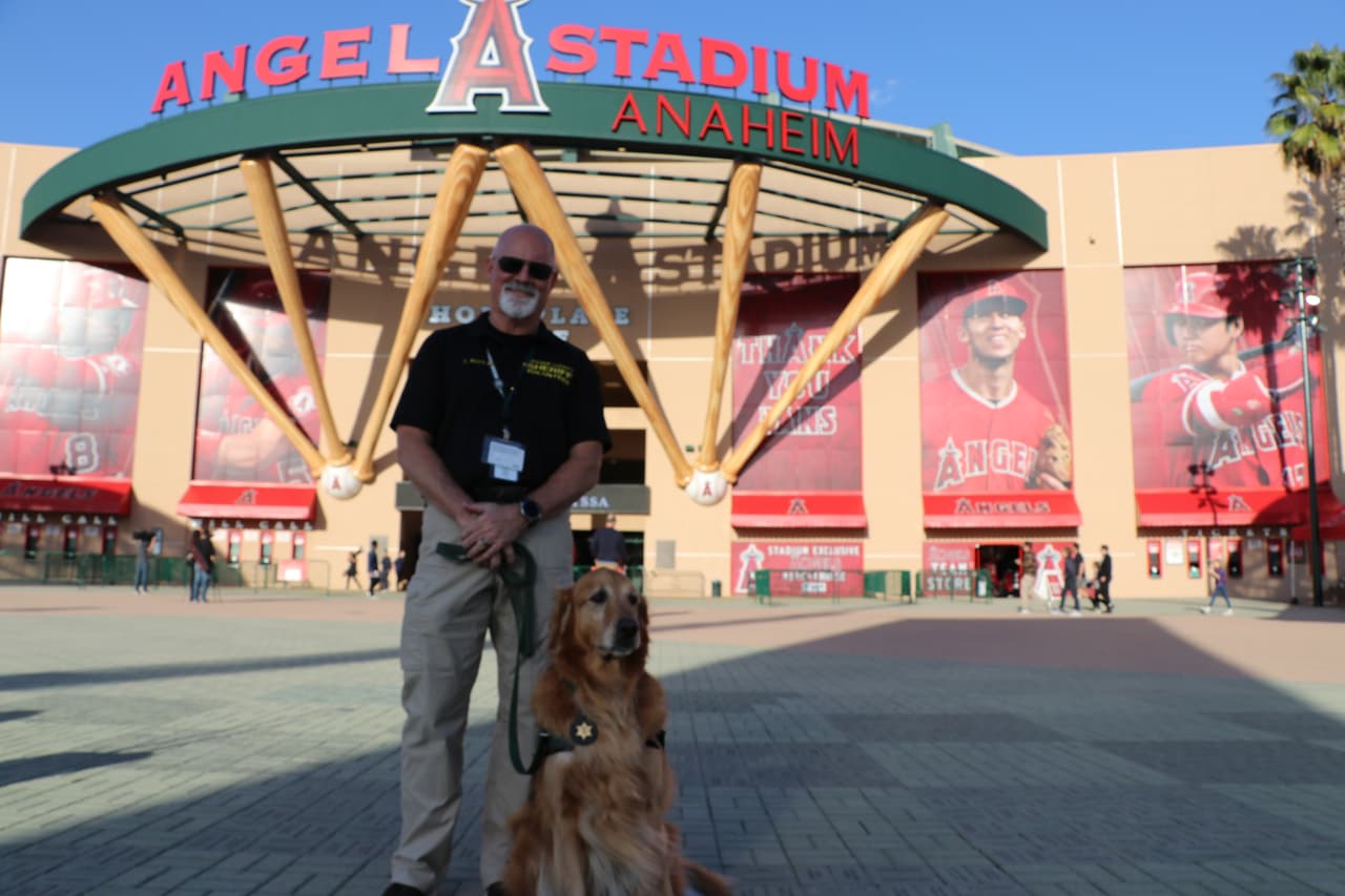 El agente del alguacil del condado de Orange, Steve Booth y su perro “Henry”, una mascota que ayuda a confortar a las personas.