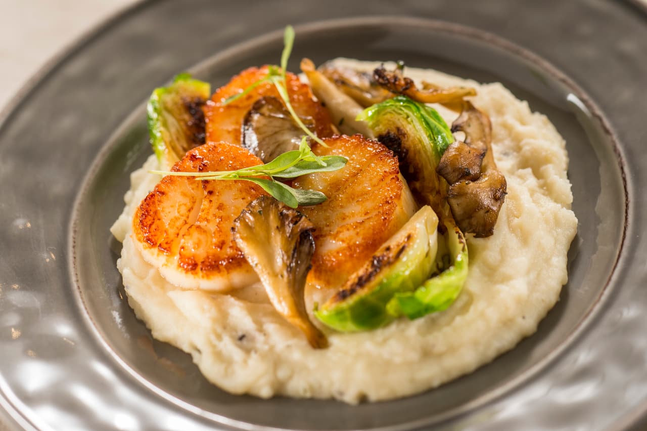 <b>Callo de hacha</b>
<br>Sellado con coles de bruselas, puré de apio trufado y hongos salvales. Una especialidad de 
<b><a href="http://www.disneyfoodblog.com/wine-and-dine-studio-2016-epcot-food-and-wine-festival/">Wine and Dine Studio</a></b>, un nuevo espacio dentro de este festival donde también puedes probar un trío de quesos gourmet con vino.