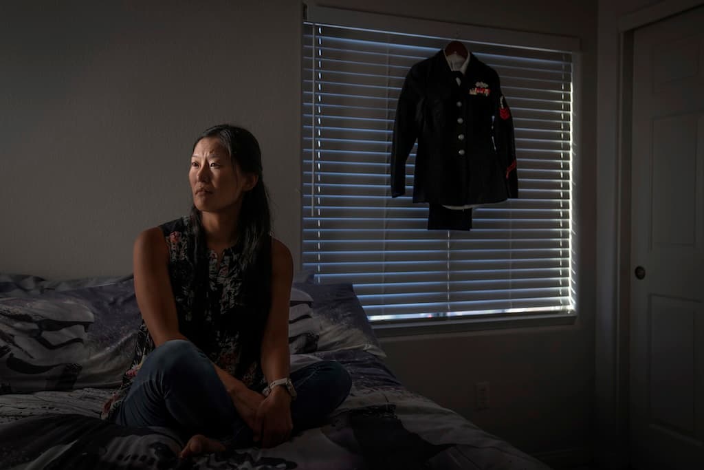 Leah Elmquist posa para un retrato mientras su uniforme de la Marina cuelga en su casa, el miércoles 26 de junio de 2024, en Las Vegas. Elmquist estaba entre los miles de adoptados que se quedaron sin ciudadanía debido a lagunas en la ley estadounidense. Se destacó en el ejército, pero no era elegible para ciertas autorizaciones de seguridad. Se fue después de una década, y luego se mantuvo discreta por temor a ser deportada.
