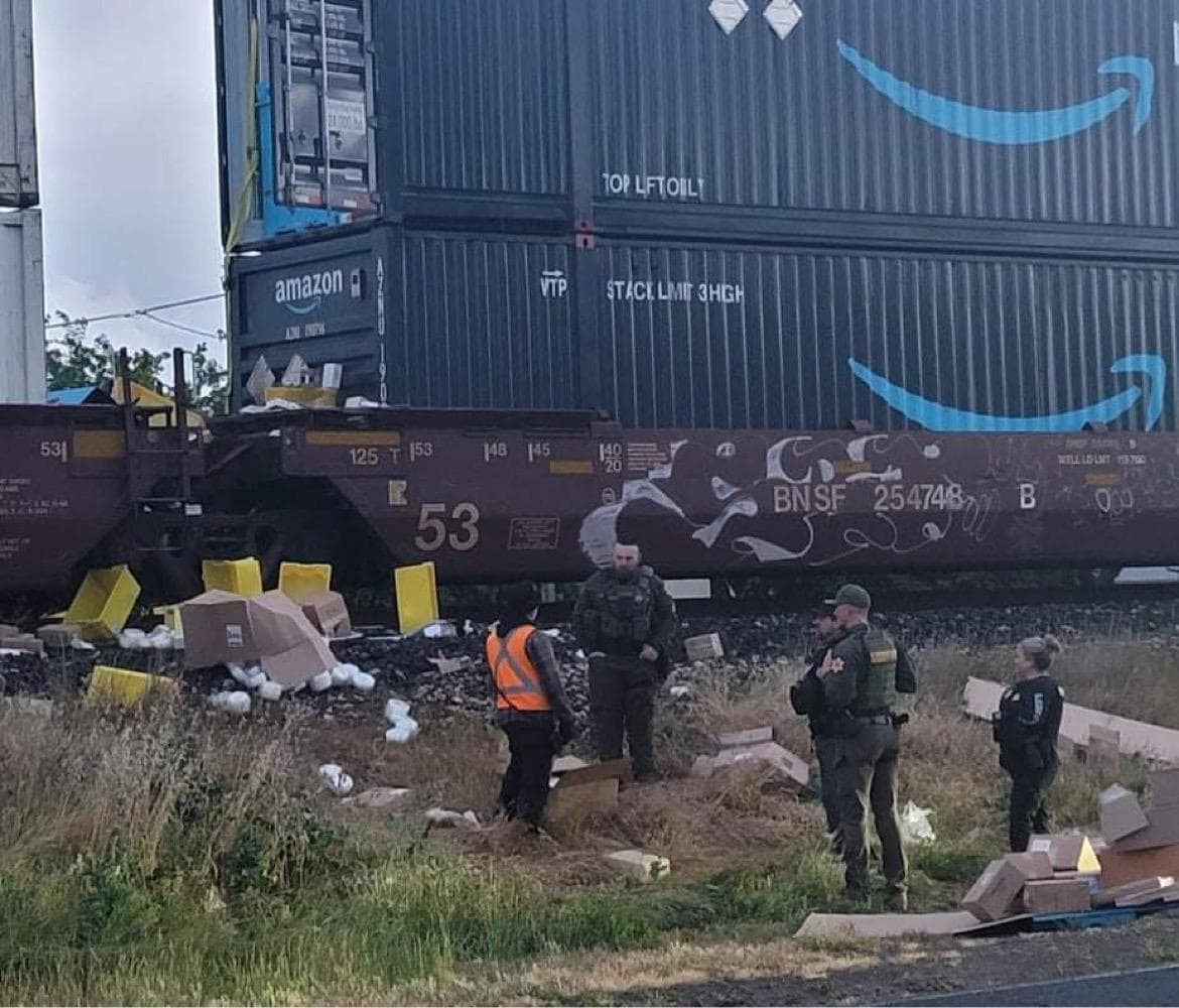 Los agentes del Sheriff inspeccionan el área en donde fueron forzados los candados de los contenedores. Se ven envolturas y paquetes regados por el suelo alrededor de las vías.