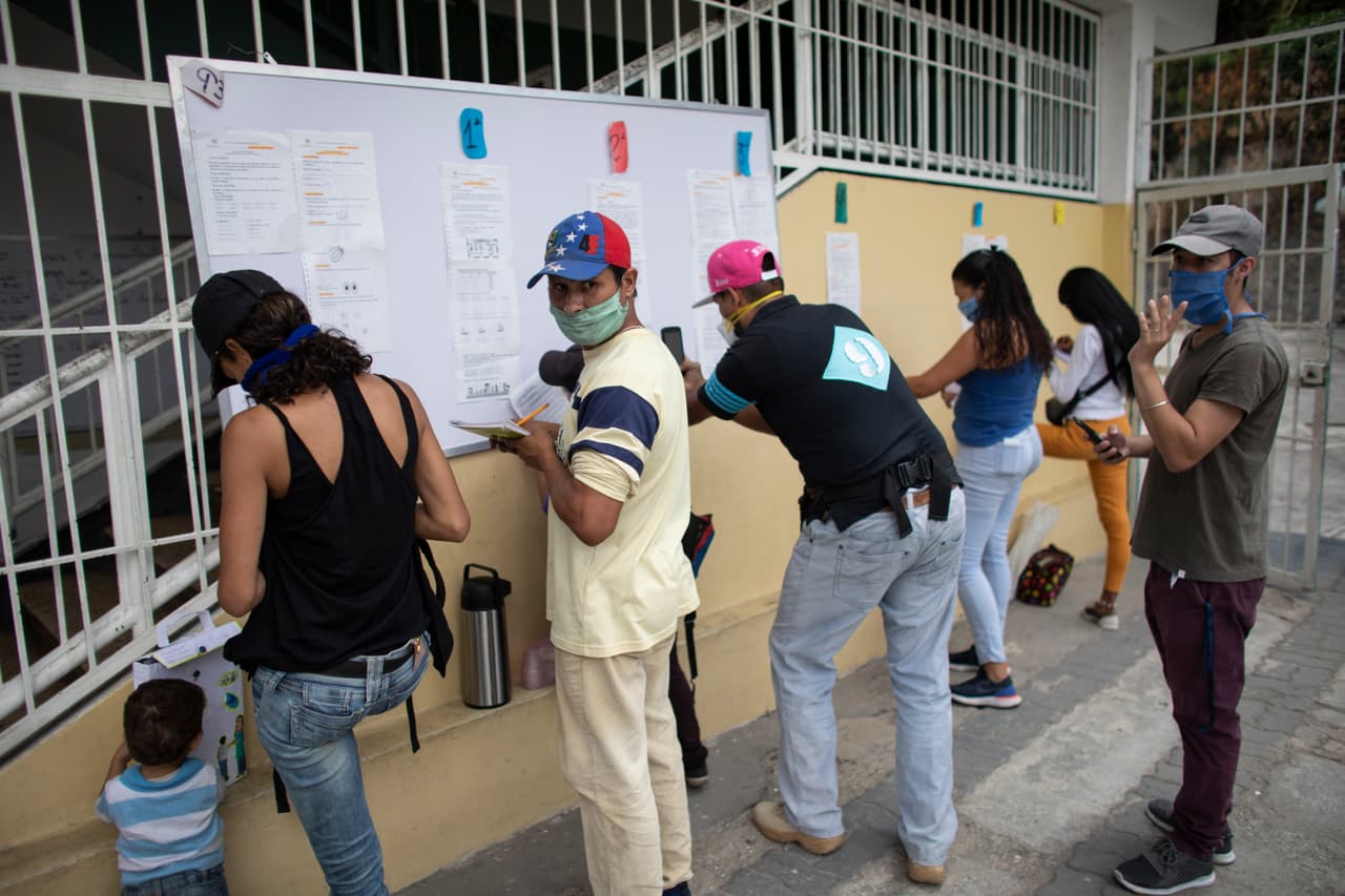 <b>Clases a distancia sin internet. </b>Un grupo de padres se reúne
<b> </b>frente a una escuela en Caracas, Venezuela, para copiar las tareas de la semana que deben hacer sus hijos en casa. El país sudamericano tiene un servicio de Internet inestable y muy lento, y sólo una porción de la población puede realizar clases en línea. 27 de abril.
<br>