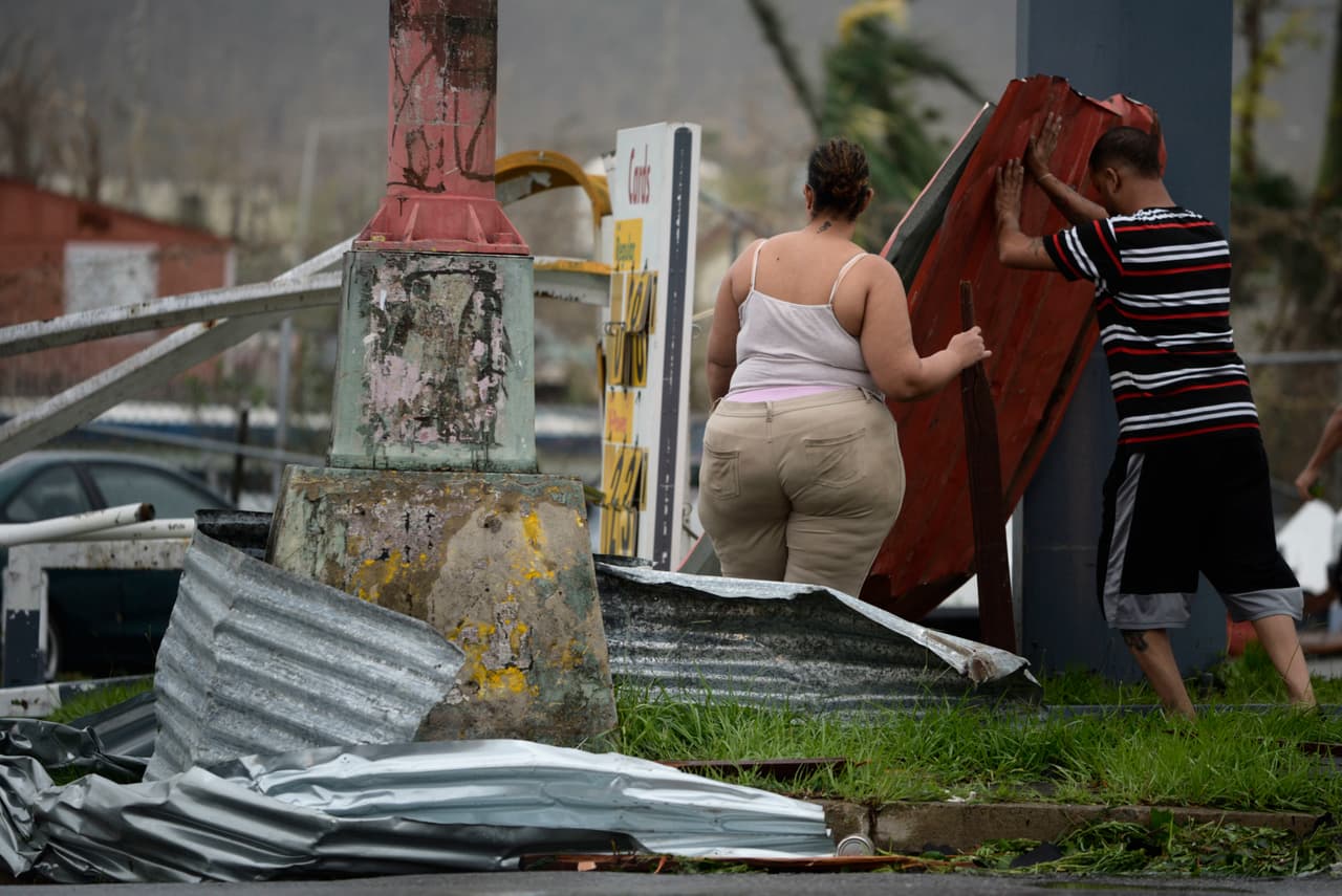 Residentes mueven paneles de aluminio en una intersección en Humacao, Puerto Rico.