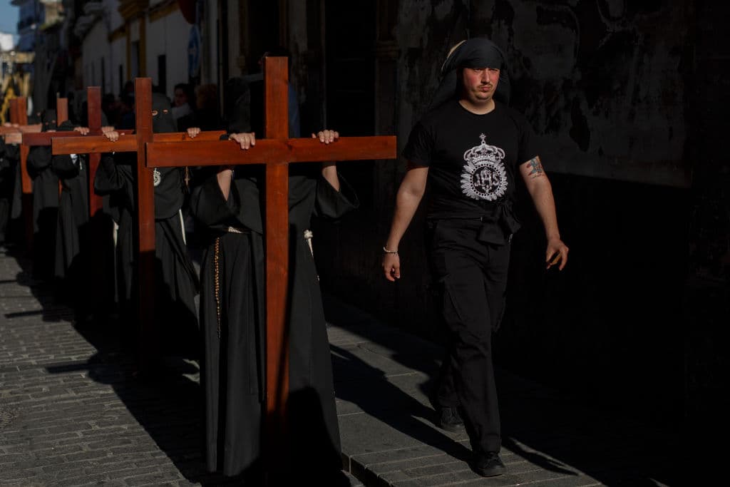 Penitentes de la hermandad de El Nazareno cargan sus cruces por las calles de la ciudad española.