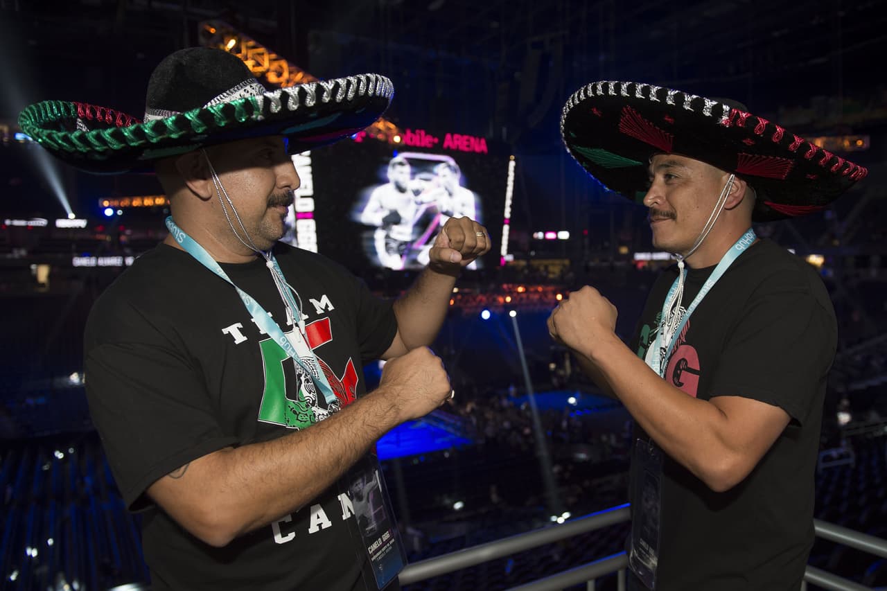 Previo a la pelea, un par de aficionados calentando motores con sendos sombreros de mariachi.