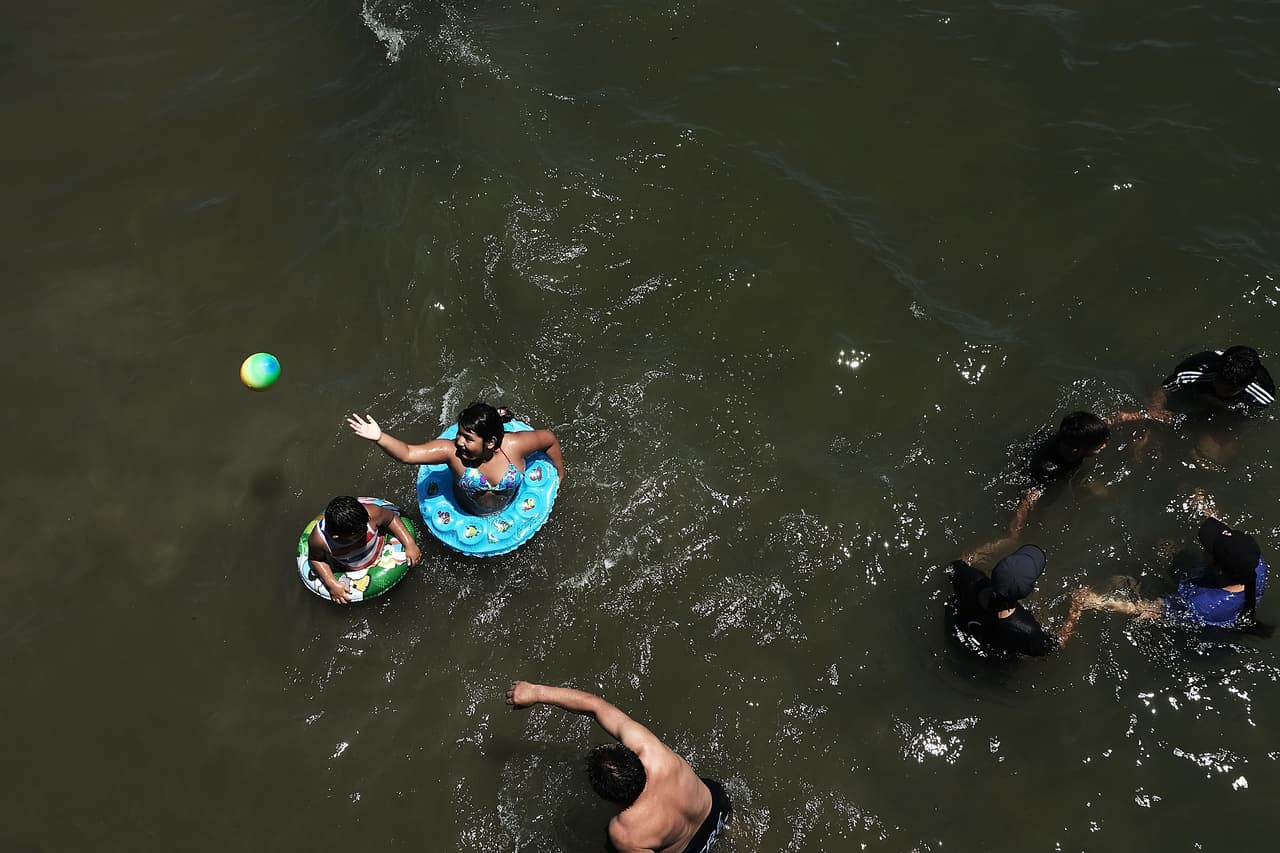 Una familia juega en el agua en la playa de Coney Island.