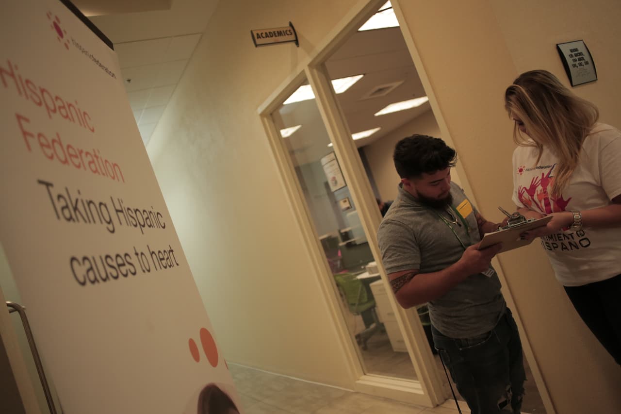 Carolina Wassmer (der.) ayuda a registrar a votantes hispanos en Orlando.