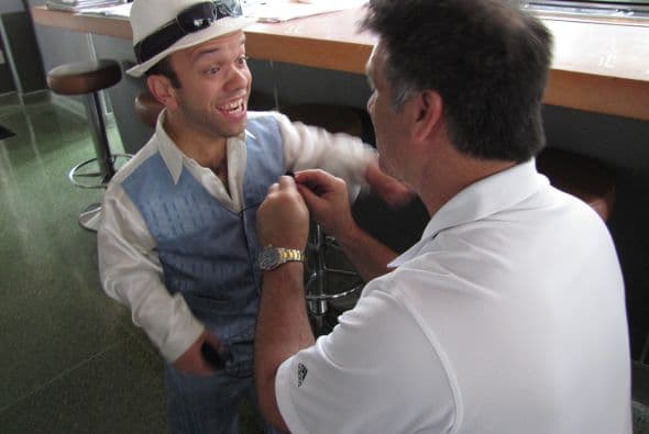 Mientras le ponen el micrófono a Juanito él bromea.