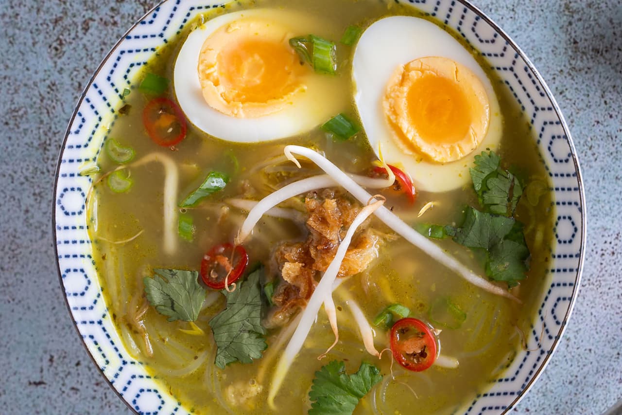 <b>Soto ayam</b>
<br>
<br>
<b>Origen: Indonesia</b>
<br>
<br>Esta sopa de pollo con fideos se condimenta con cúrcuma fresca, anís estrellado, canela, hierba de limón y hojas de lima, y se añaden huevos hervidos para una riqueza adicional.
<br>
<br>Cada parte de Indonesia la hace con su toque local. También es popular en Singapur, Malasia y en el lejano Surinam, en América del Sur, donde la receta llegó con
<br>
<br>los inmigrantes javaneses.
<br>
