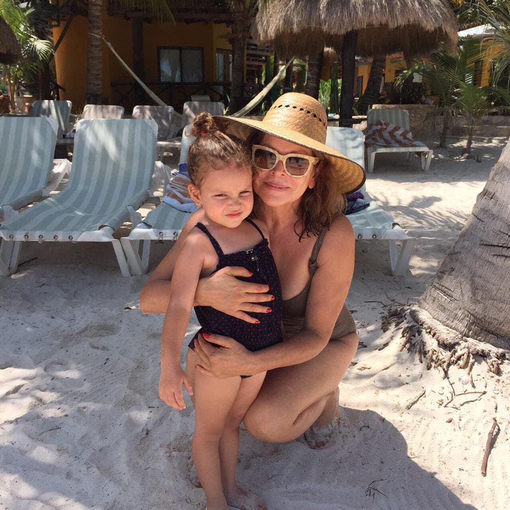 Compartiendo el tiempo con su adorable nieta en la suave arena de Holbox en Quintana Roo.