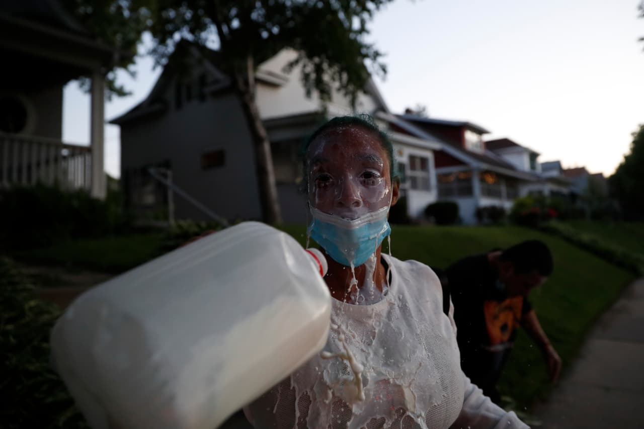 Esta manifestante se limpia los ojos y la cara después de haber inhalado gases lacrimógenos lanzados por la policía de Minnesota.