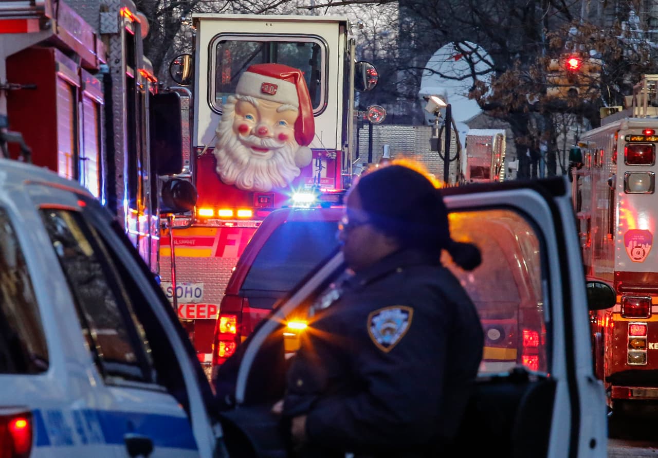 El fuego se desató poco antes de las 7:00 de la tarde del jueves. "Empezó en el primer nivel y se extendió rápidamente a niveles superiores. Murieron personas en varios pisos, desde 1 a 50 años", dijo el comisionado del departamento de Bomberos, Daniel Nigro. En la foto, una figura de Santa Claus colgada de una puerta de un camión de bomberos de Nueva York.
<br>