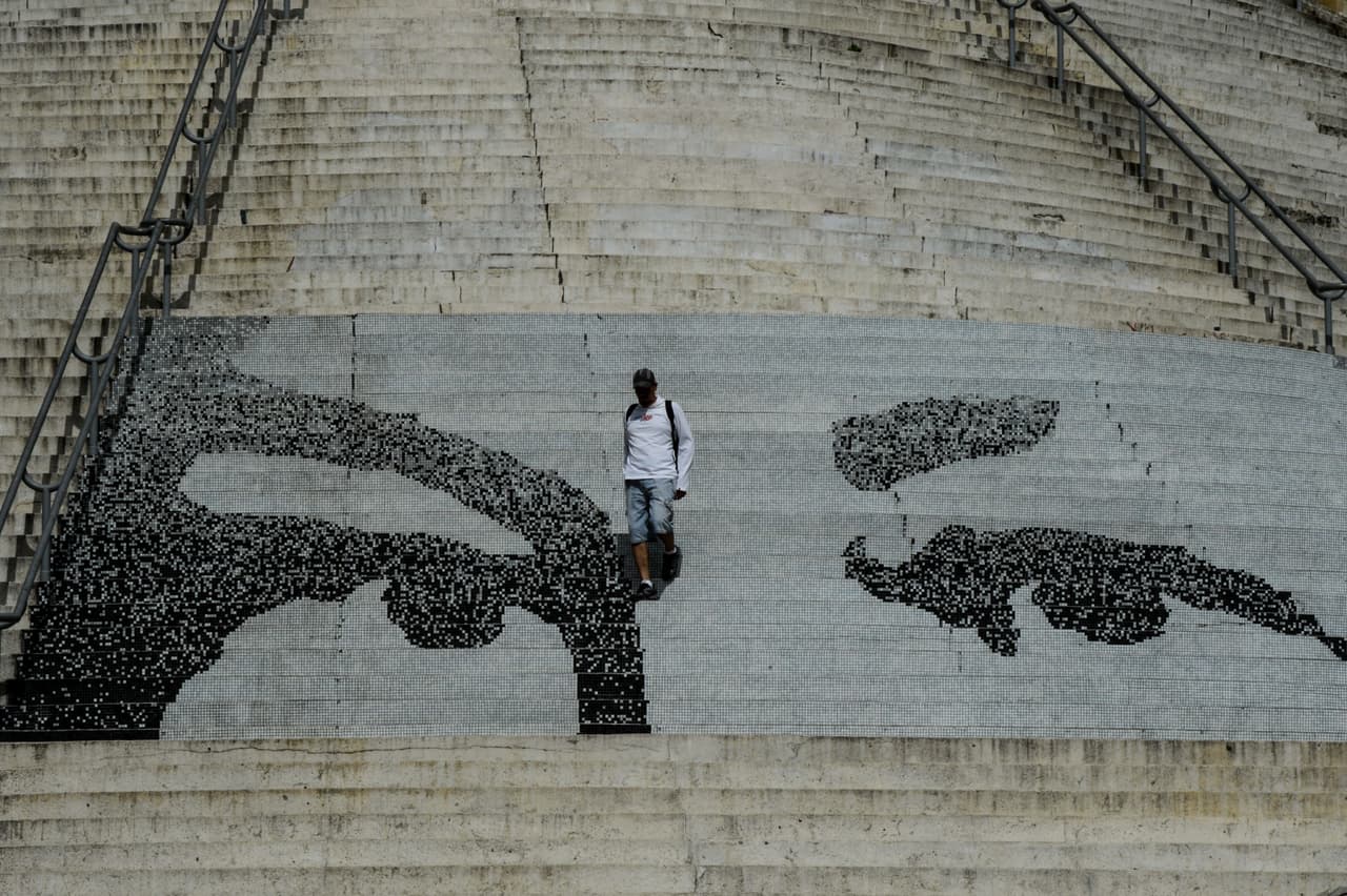 Un hombre baja las escalinatas de la plaza El Calvario, en el centro de Caracas, decoradas con una reproducción de los ojos de Hugo Chávez.