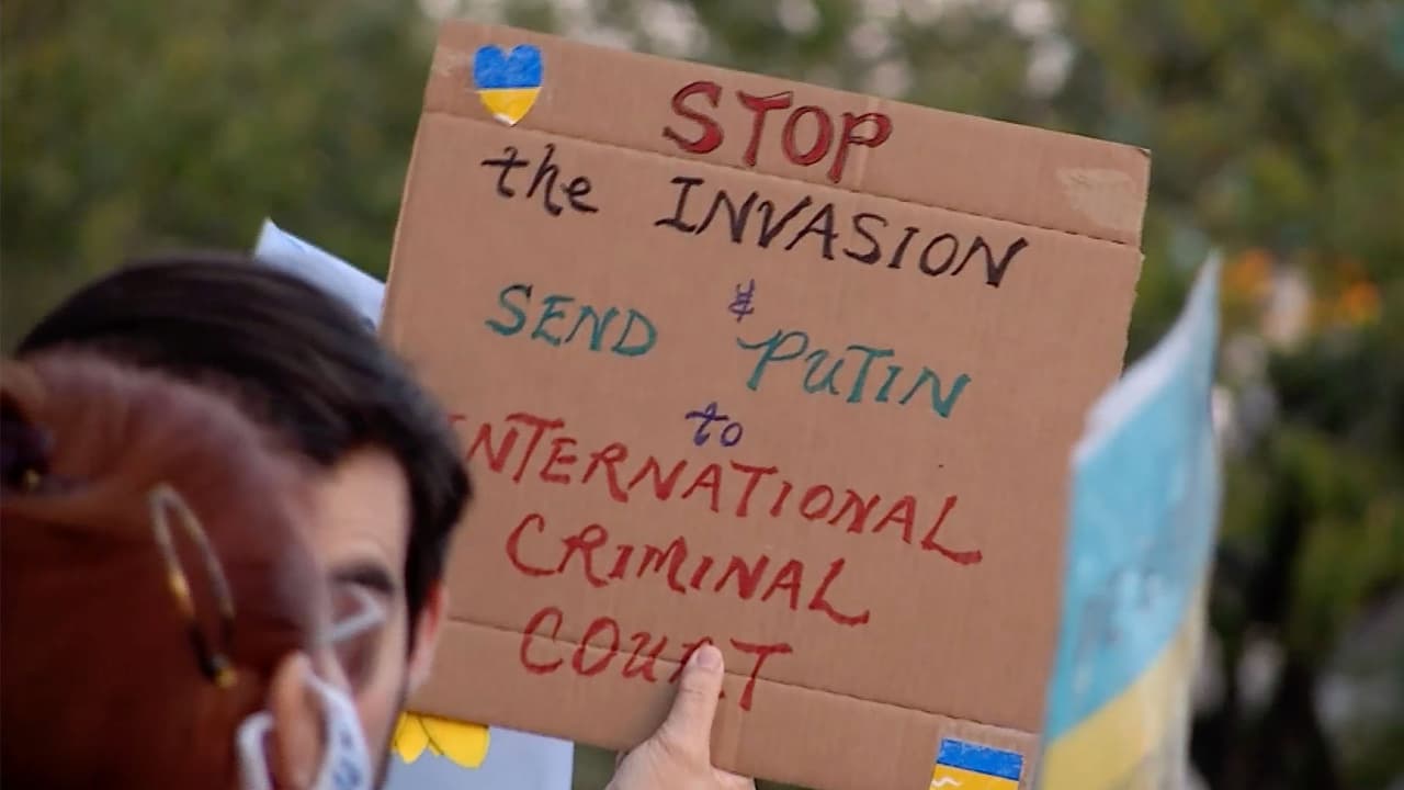 "Detengan la invasión y envíen a Putin a la Corte Internacional de Justicia", dice la pancarta de uno de los manifestantes.