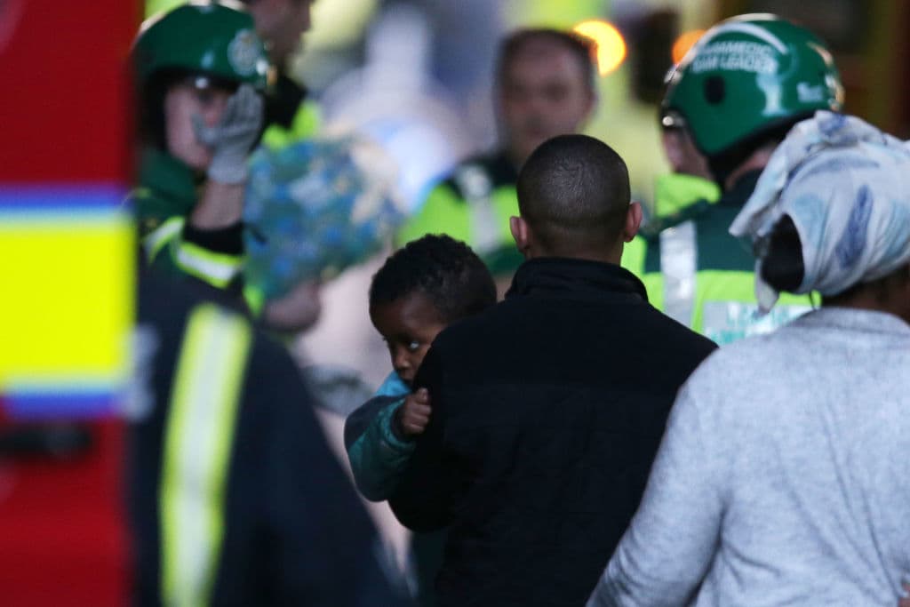 Los equipos de bomberos y paramédicos atendieron a los vecinos ante la emergencia por el incendio. Acá llevan a un niño cargado hasta una zona segura.