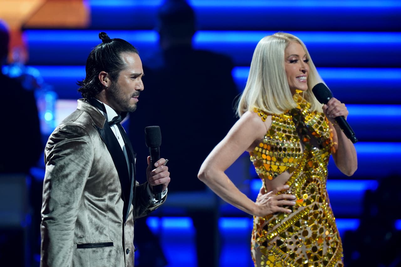 El modelo estaba decorado con lentejuelas doradas en diferentes formas: circulares, triangulares, en forma de gota y en rombo. El vestido también tenía el cuello alto, no tenía mangas y presentaba transparencias.