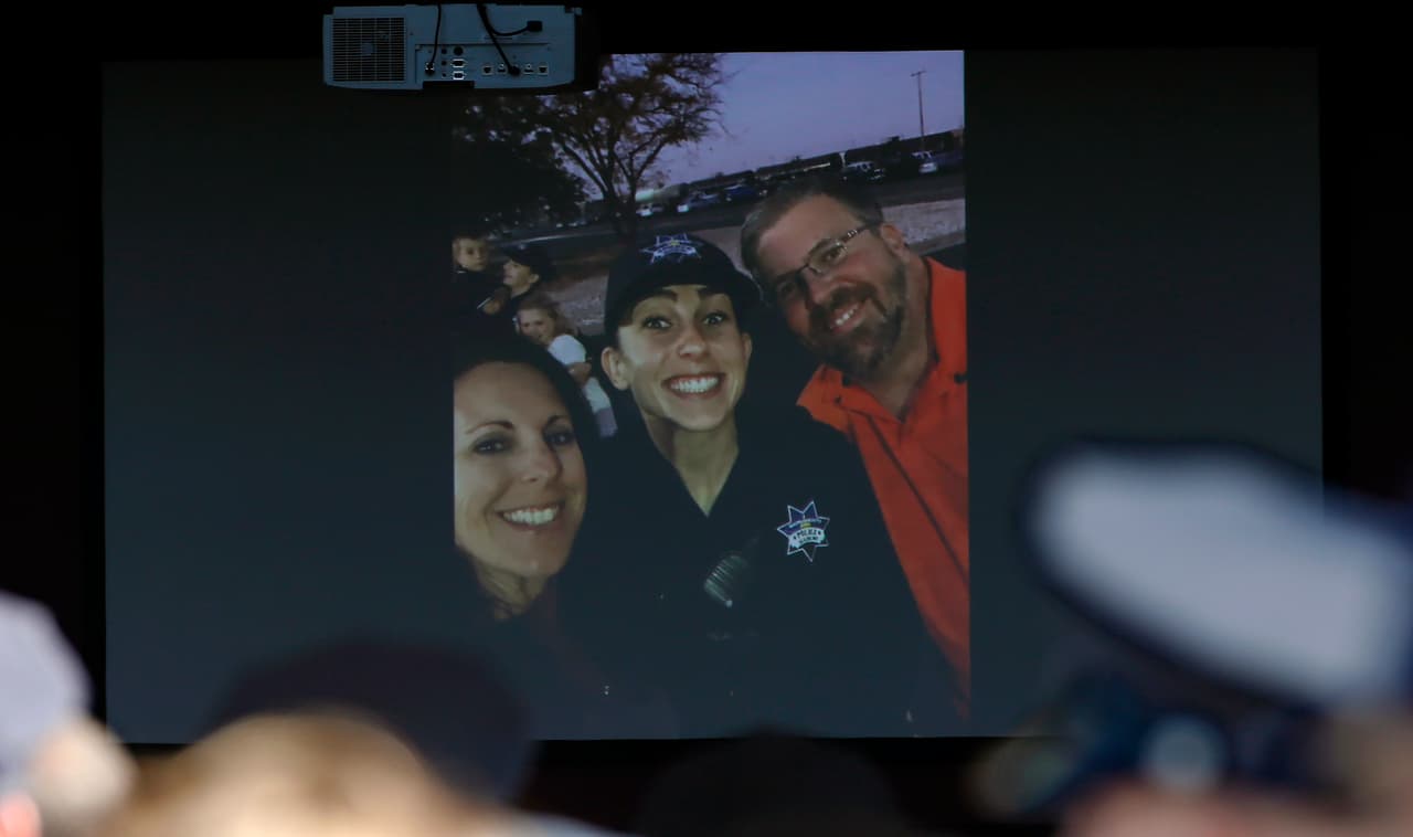 Una fotografía de la oficial Tara O'Sullivan junto con sus padres, Kelley, izquierda, y Denis, derecha, se expuso en la entrada de la iglesia Bayside Adventure para los servicios fúnebres de Tara.