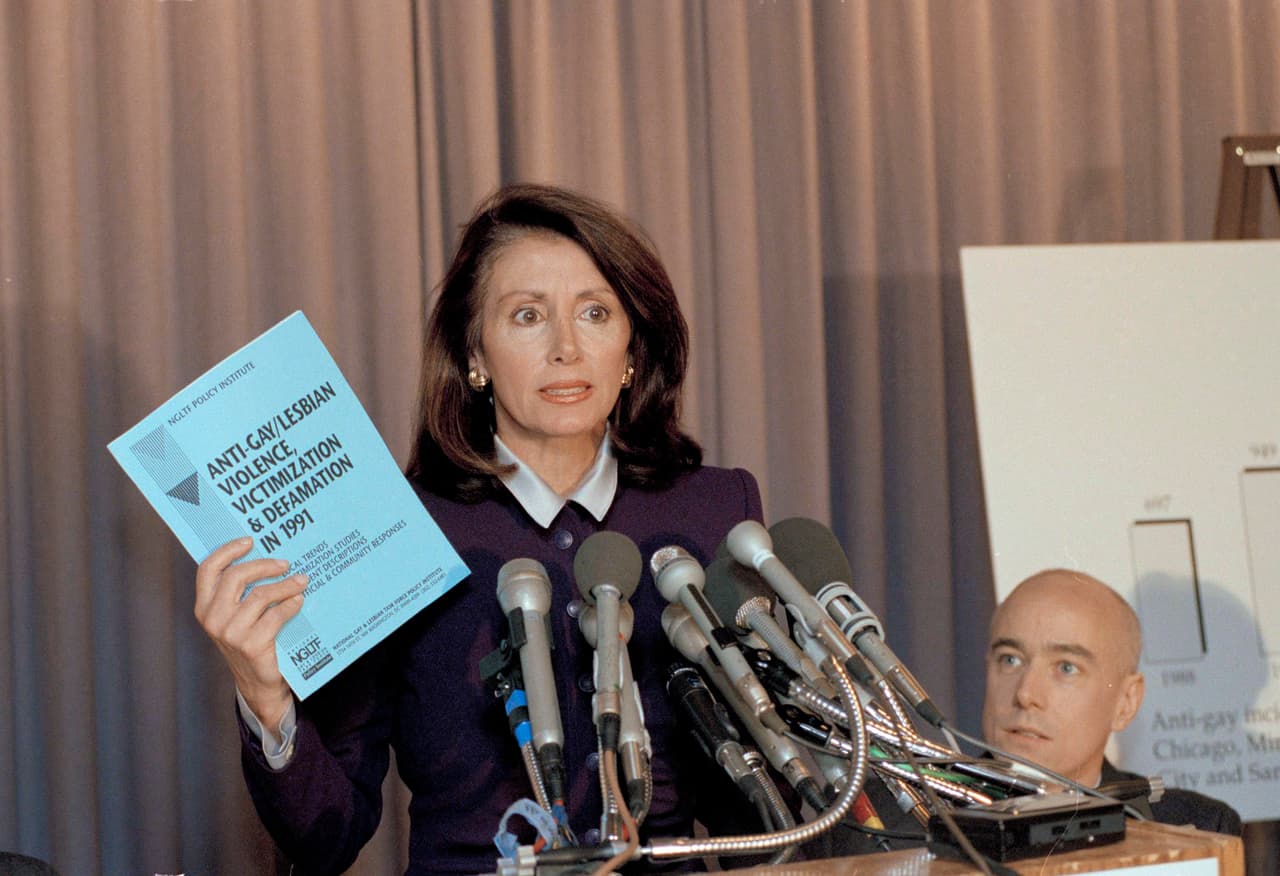 Pelosi resumió su carrera, desde que vio el Capitolio por primera vez cuando era niña con su padre, un excongresista y alcalde, hasta servir como oradora junto a los presidentes de EEUU. y hacer “el trabajo de la gente”.
<br>
<br>En la foto, la representante Nanci Pelosi sostiene una copia de un informe sobre la violencia gay durante una conferencia de prensa en el Club Nacional de Prensa en Washington el jueves 19 de marzo de 1992. El informe del Instituto Nacional de Políticas del Grupo de Trabajo para Gays y Lesbianas afirma que la violencia contra los homosexuales aumentó un 31 por ciento el año pasado . Kevin Berill, director del Proyecto Anti-Violencia del Instituto mira a la derecha.