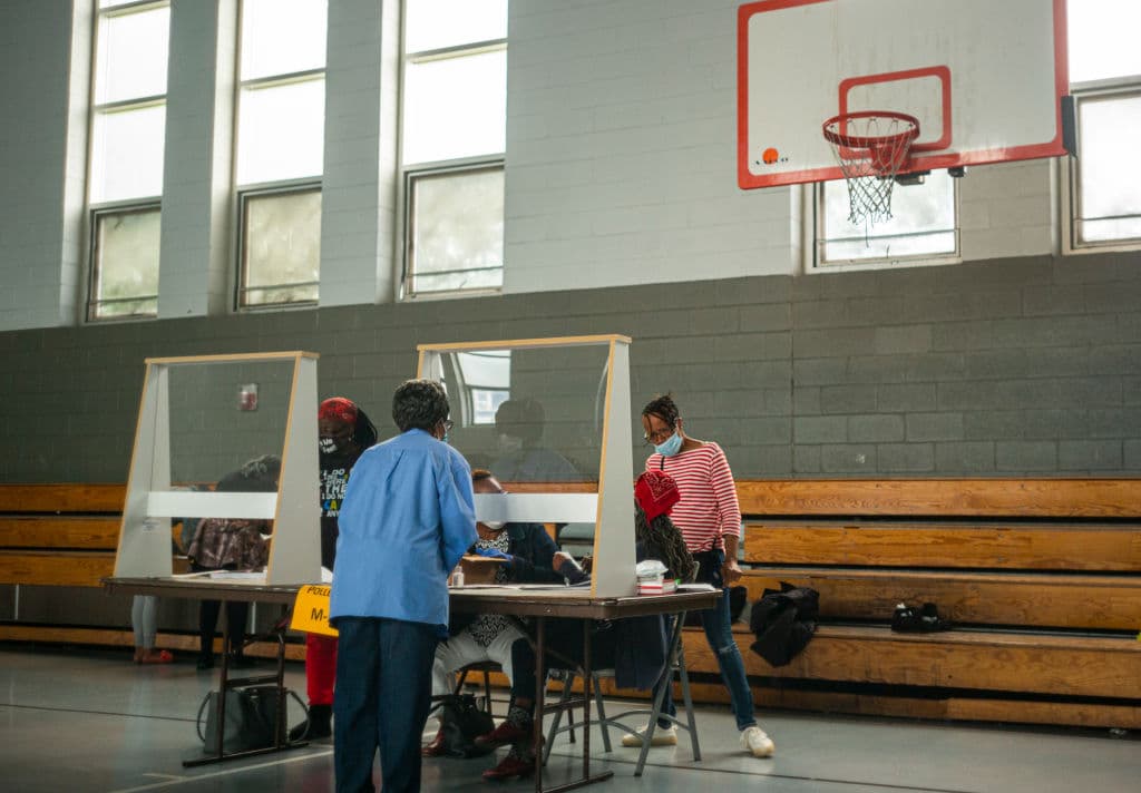 Trabajadores electorales se sientan detrás de las barreras de plexiglás durante las elecciones primarias en Filadelfia. Debido a la pandemia de coronavirus, el Departamento de Estado proporcionó a los condados máscaras y protectores faciales para los trabajadores electorales.
<br>
