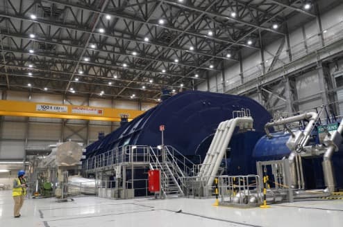 Un miembro de la prensa se encuentra en la sala de turbinas de Olkiluoto 3 (OL3), el reactor nuclear más grande de Europa, durante una visita de prensa a la isla de Olkiluoto, Finlandia, el martes 24 de febrero de 2026.