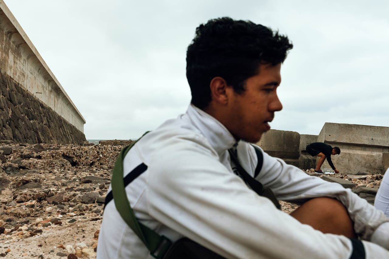 La legislación española contempla que todo inmigrante menor no acompañado debe contar con un permiso de residencia. Esto no sucede de forma regular en Melilla. Cuando los jóvenes no pueden tramitar la documentación se perpetúan en un círculo de exclusión al no poder trabajar o seguir a Europa. Se quedan atrapados en la ciudad, muchas veces en situación de calle.