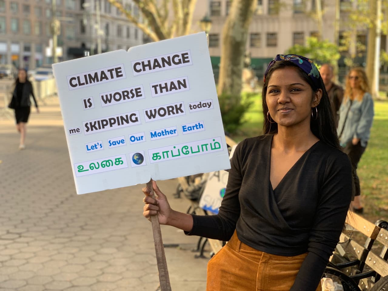 "El Cambio Climático es peor que yo faltando al trabajo hoy. Salvemos la Madre Tierra", dice en dos idiomas el letrero de esta joven, que ha llegado desde bien temprano a la manifestación.