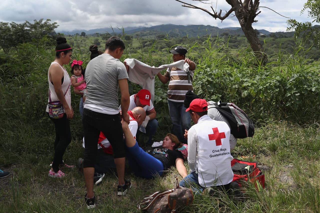 Médicos de la Cruz Roja asisten a un migrante que se derrumbó por agotamiento cerca de Quezaltepeque, Guatemala. Algunas zonas en la ruta que atraviesan los viajantes están controladas por bandas delictivas.