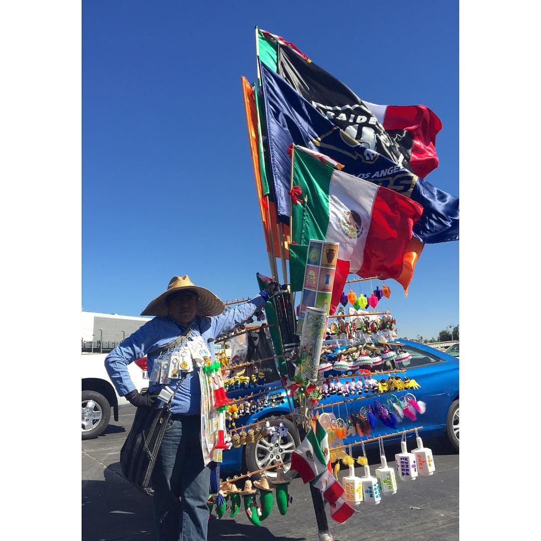Un hombre vende banderas y decorativos para autos.