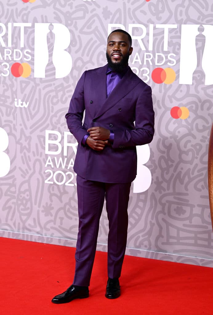 El humorista 
<b>Mo Gilligan</b> eligió un traje en color morado para hacer su aparición por la pasarela de los Brit Awards.