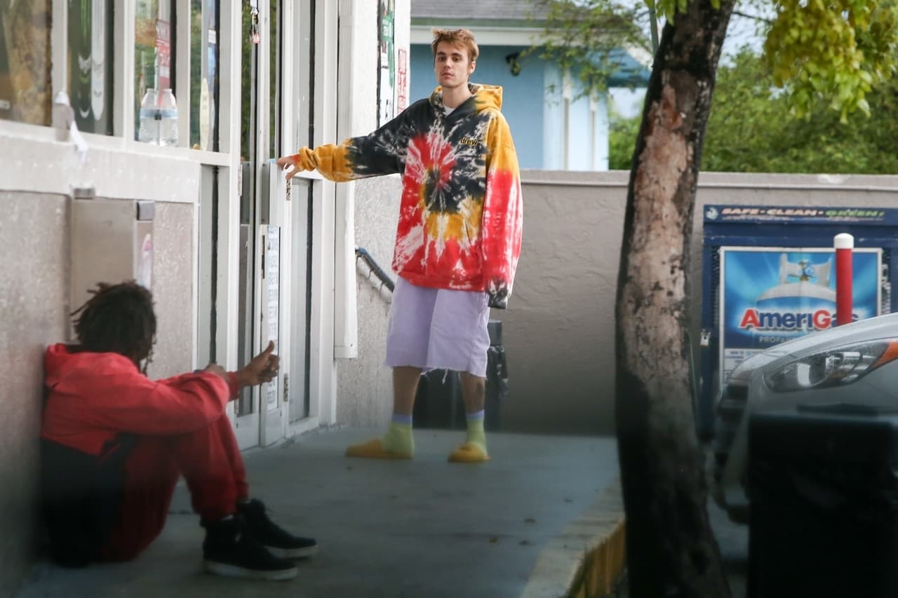 Sentado junto a la puerta de la tienda, se encontraba un hombre sin hogar que llamó la atención del intérprete de 'Love Yourself'.