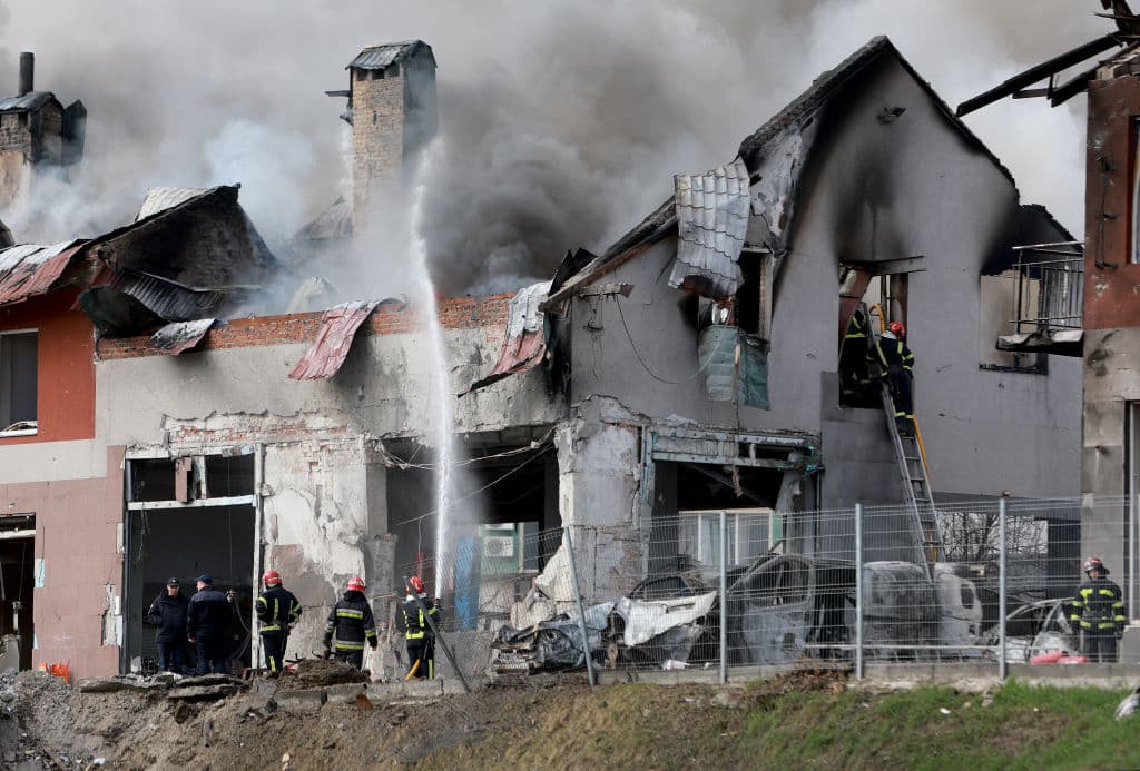 Bomberos apagando el fuego en las estructuras alcanzadas por misiles rusos en la ciudad de Leópolis.
