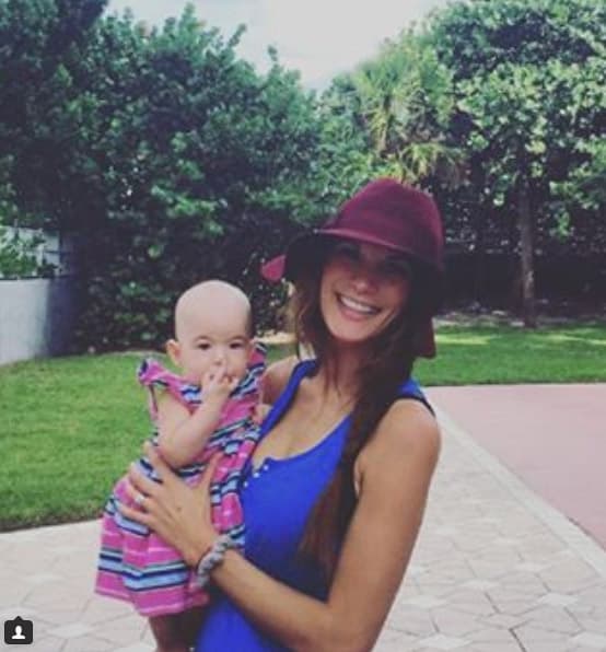 Disfrutando de la playa en brazo de su mamá Cristy.