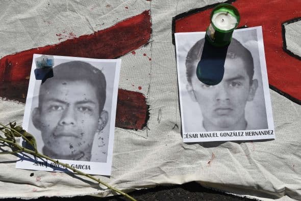Un grupo de estudiantes colocó veladoras y flores sobre los retratos de los estudiantes desaparecidos.