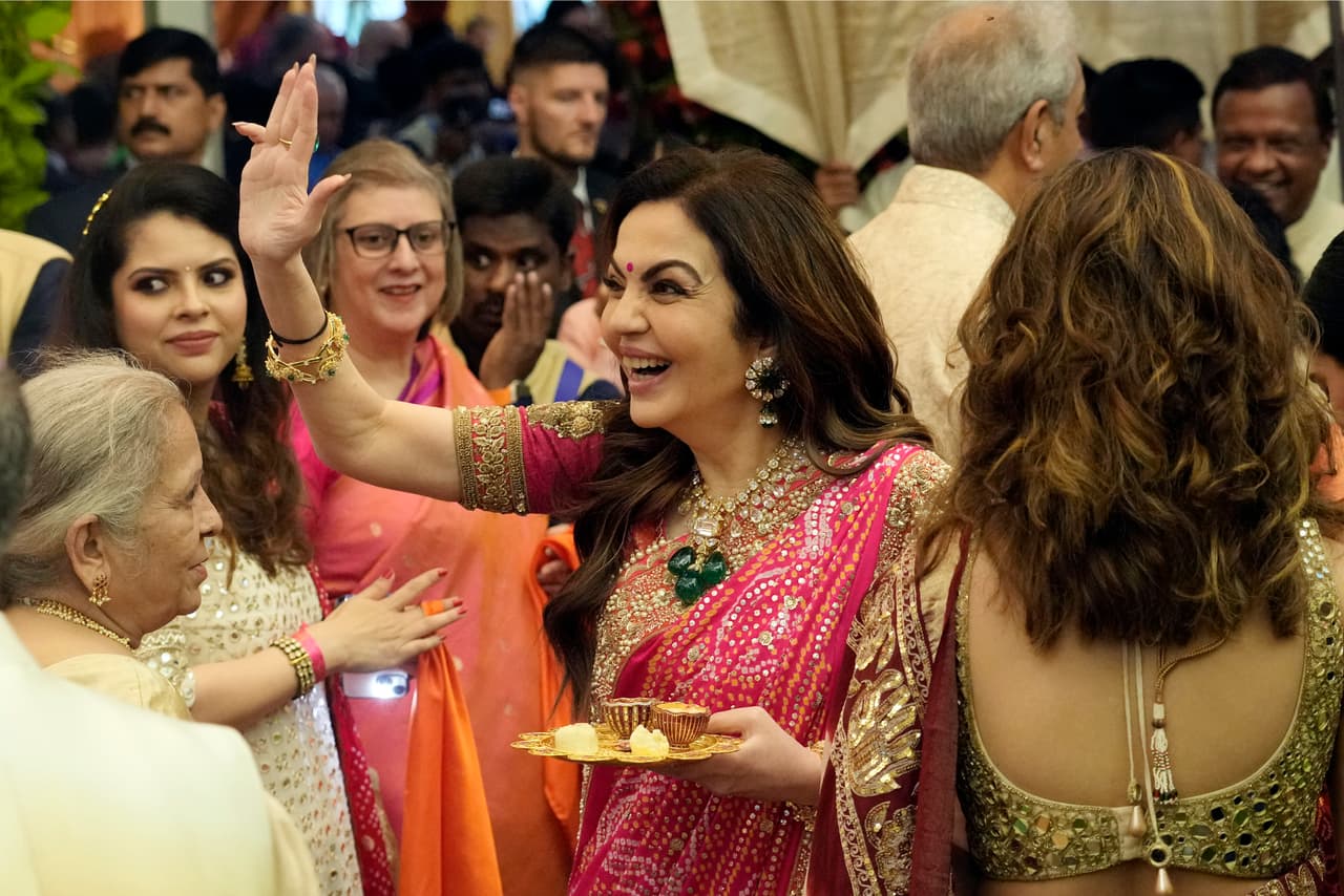 Nita Ambani, en el centro, esposa del presidente de Reliance Industries, Mukesh Ambani, saluda a los invitados durante una ceremonia previa a la boda de su hijo menor, Anant Ambani, con Radhika Merchant, el miércoles 3 de julio de 2024.
<br>
<br>En marzo, 
<b>organizaron una fiesta prenupcial de tres días para Anant a la que asistieron 1,200 invitados, entre ellos exlíderes mundiales, magnates tecnológicos y megaestrellas de Bollywood, y actuaciones de Rihanna, Akon y Diljit Dosanjh, </b>un cantante punjabi que saltó a la fama internacional cuando actuó en Coachella. Al evento también asistieron los multimillonarios tecnológicos Mark Zuckerberg y Bill Gates.
<br>
<br>