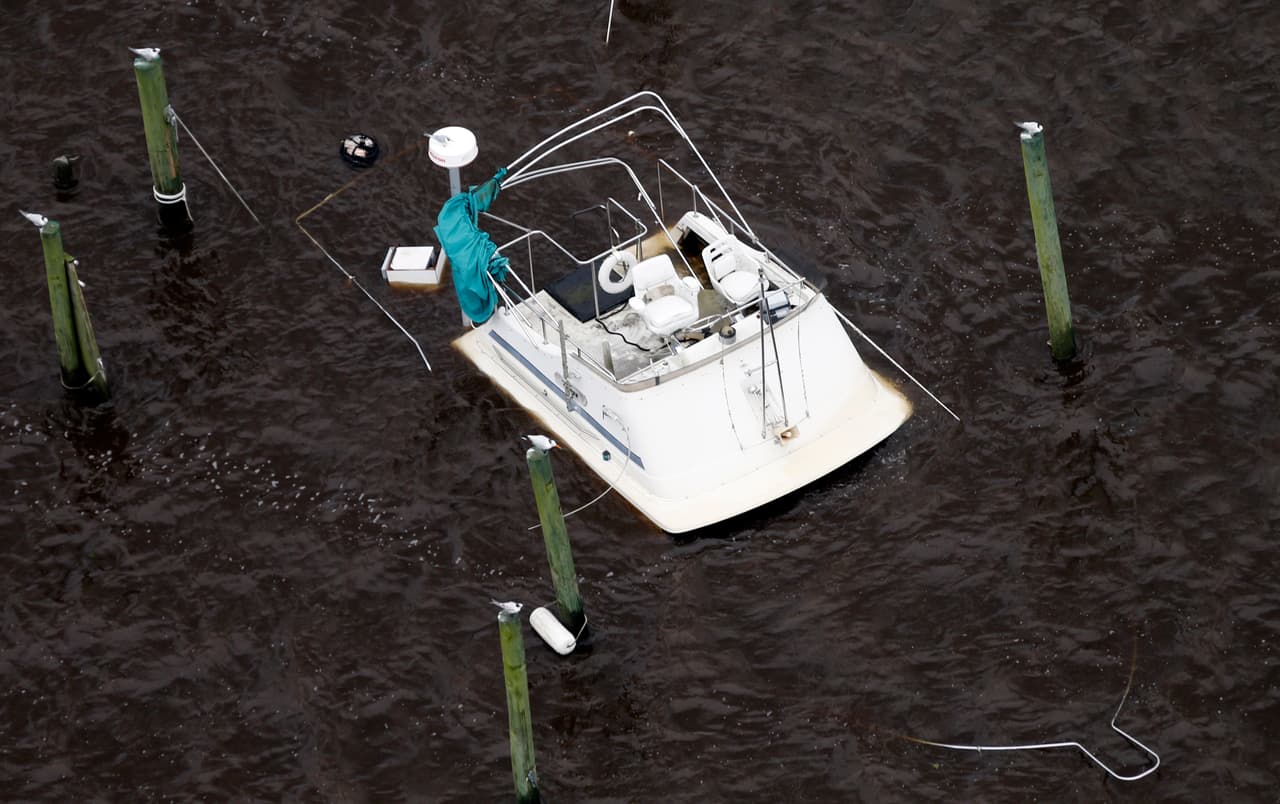 El puente y la barandilla de proa de un yate son lo único visible por encima de las aguas de la inundación del río New, tras el paso de Florence por Jacksonville, en Carolina del Norte.