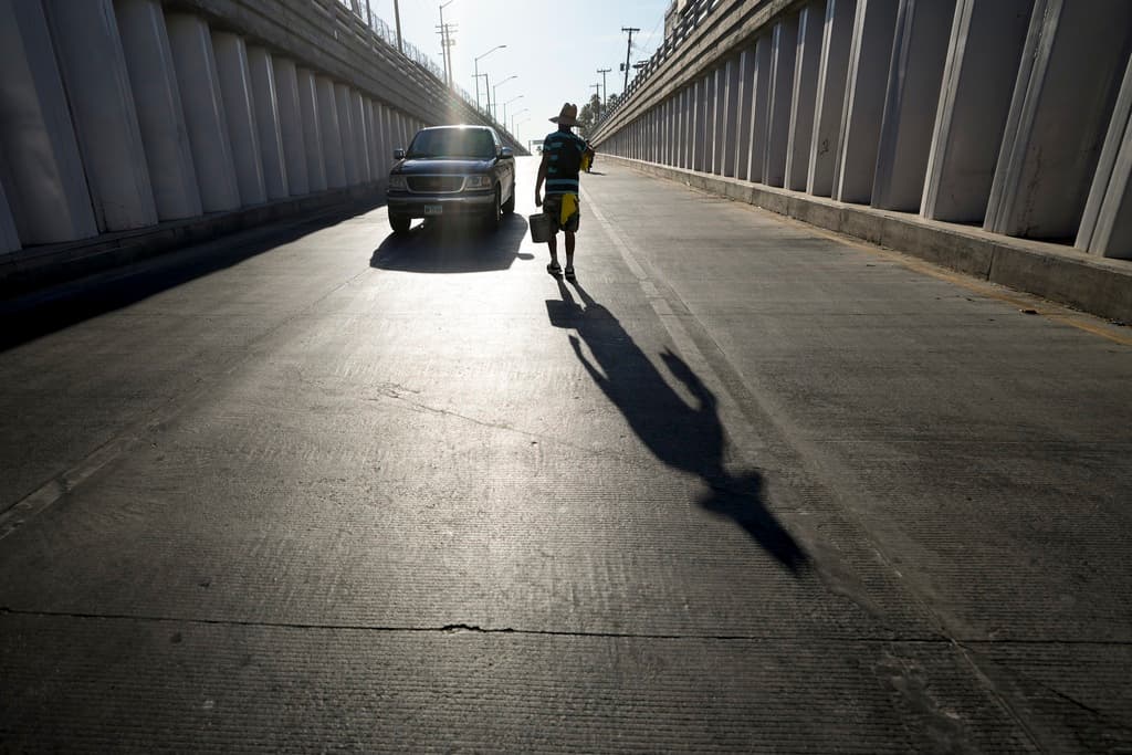 Victor Hernández camina mientras hace su trabajo como limpiavidrios de coches en Calexico, California. Hernández explicó a la agencia AP que solo trabaja hasta las 10 de la mañana debido al intenso calor.