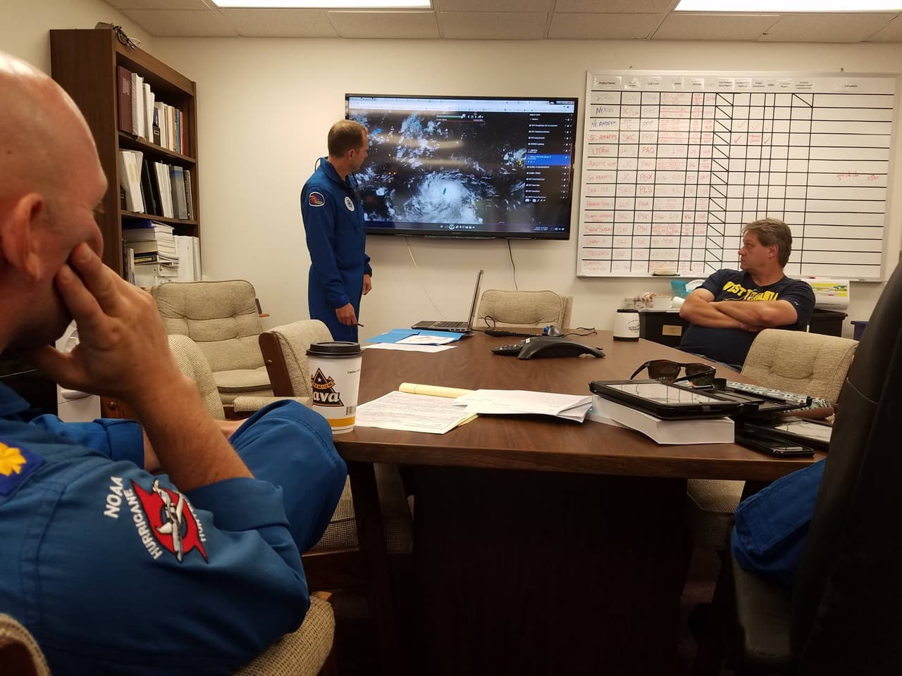 Antes de ingresar a una tormenta, la tripulación del cazatormentas #NOAA49 se prepara conociendo las características del huracán. Por ejemplo, aquí Mike Holmes (meteorólogo) informa a los especialistas que son, de izquierda a derecha Ron Moyers (Piloto), Holmes y John Hill (Ingeniero). Fotografía Paul Flaherty (NOAA). Ellos hicieron misión el 2 de octubre durante 8,5 horas.