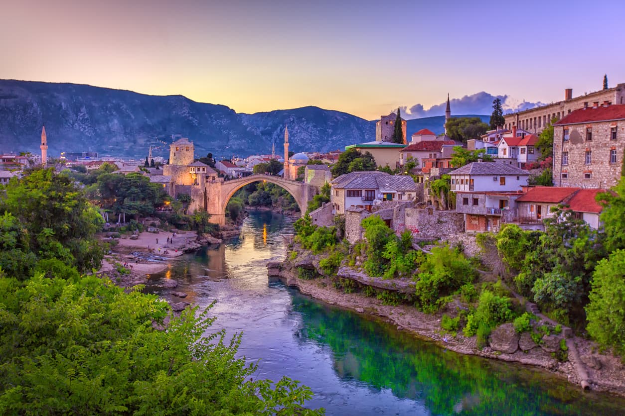 <b>Mostar, Bosnia y Herzegovina. </b>La ciudad está situada en el río Neretva y sus orígenes datan del XV como una ciudad fronteriza otomana y luego durante el período austrohúngaro en el siglo XIX. La arquitectura turca, otomanas, mediterráneas y europeas occidentales convergen con el Puente Viejo, Stari Most, sobre el río, en un profundo valle verde. El conflicto armado de los 1990 dejó casi todo completamente destruido, pero la reconstrucción del casco se ha establecido como 
<a href="https://whc.unesco.org/en/list/946/" target="_blank">patrimonio por UNESCO</a>.