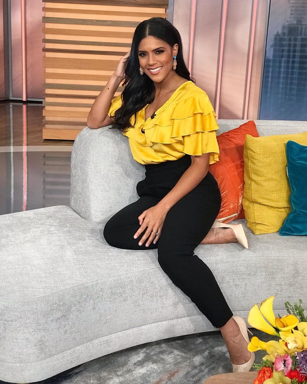 Los diseños con más volumen te mantendrán cómoda en los días de clima intermedio. Francisca optó combinar el bello top amarillo con volantes solo con un pantalón entubado negro y 'stilletos' beige.