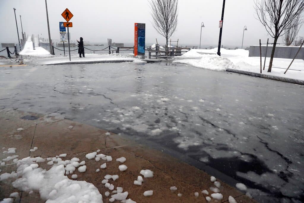Aguas semicongeladas del puerto de Boston cubren calles aledañas este sábado.