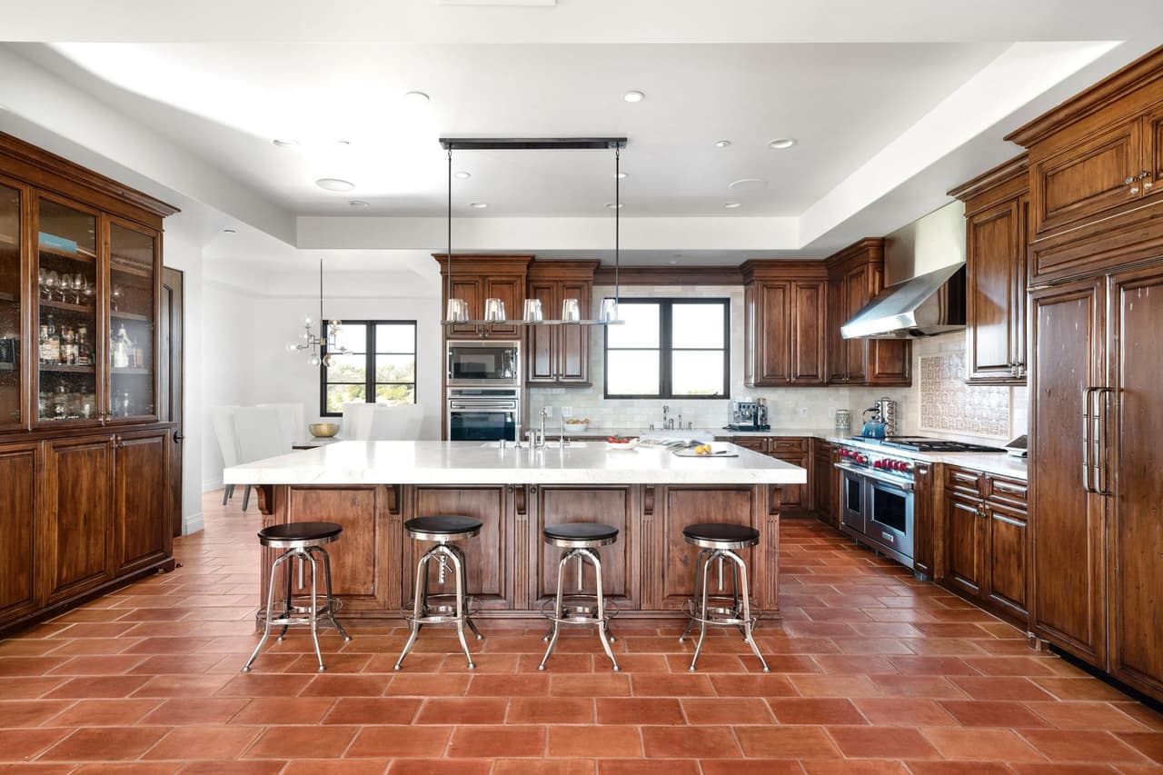La cocina cuenta con gabinetes de madera y con una mesa al estilo de isla.