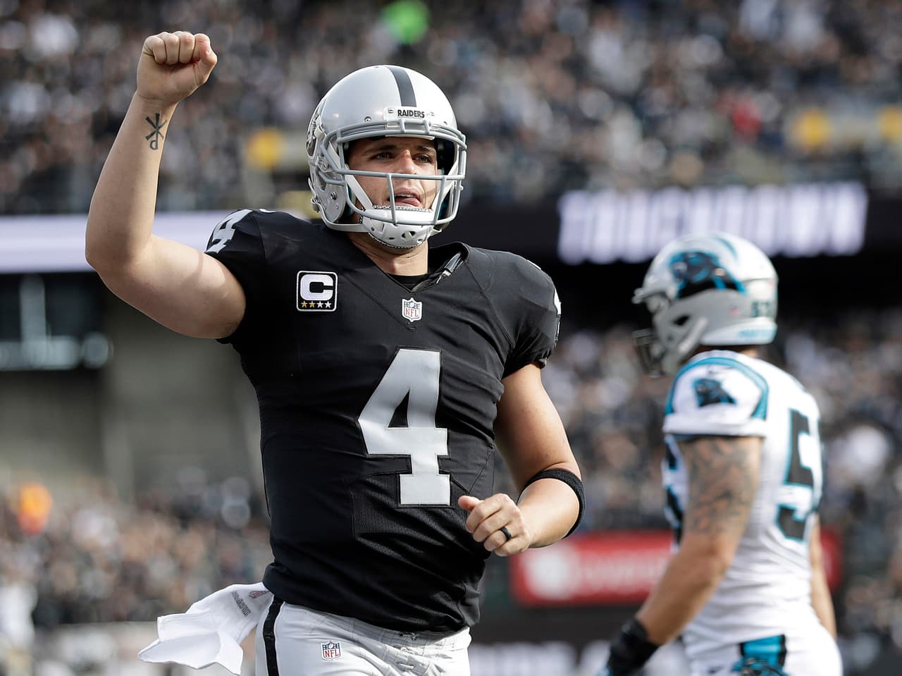 Oakland Raiders quarterback Derek Carr (4) celebrates after throwing a touchdown pass against the Carolina Panthers during the first half of an NFL football game in Oakland, Calif., Sunday, Nov. 27, 2016. (AP Photo/Marcio Jose Sanchez)