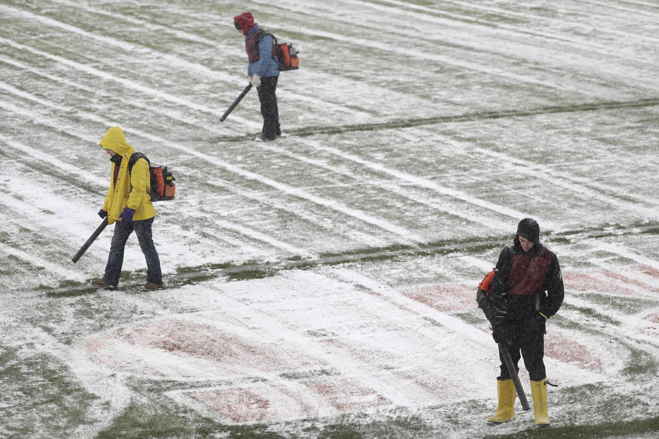 Trabajadores limpian en Nochebuena la nieve en el estadio Soldier Field de Chicago antes del partido de NFL entre los Chicago Bears y los Cleveland Browns.