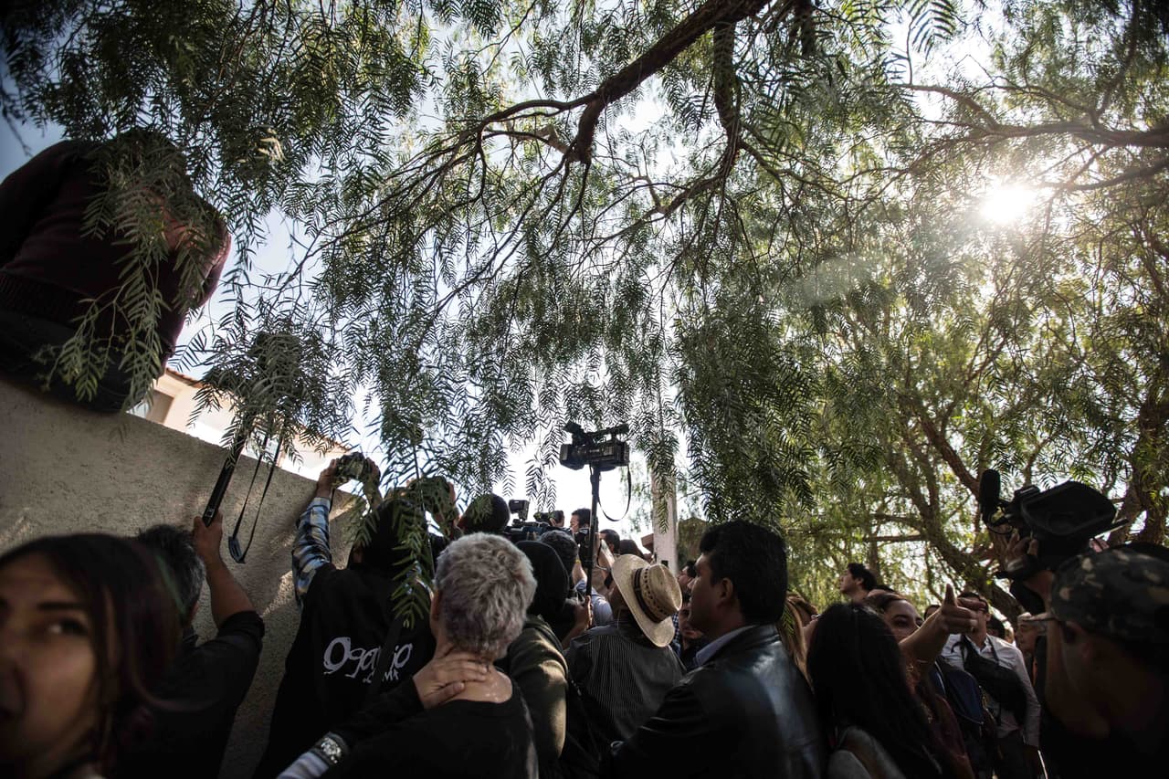 Periodistas y curiosos se agolpan fuera de la casa de los Ibarra la mañana del evento. Algunos elevan sus cámaras con trípodes, usan escalones y hasta se cuelan en la casa sin permiso.