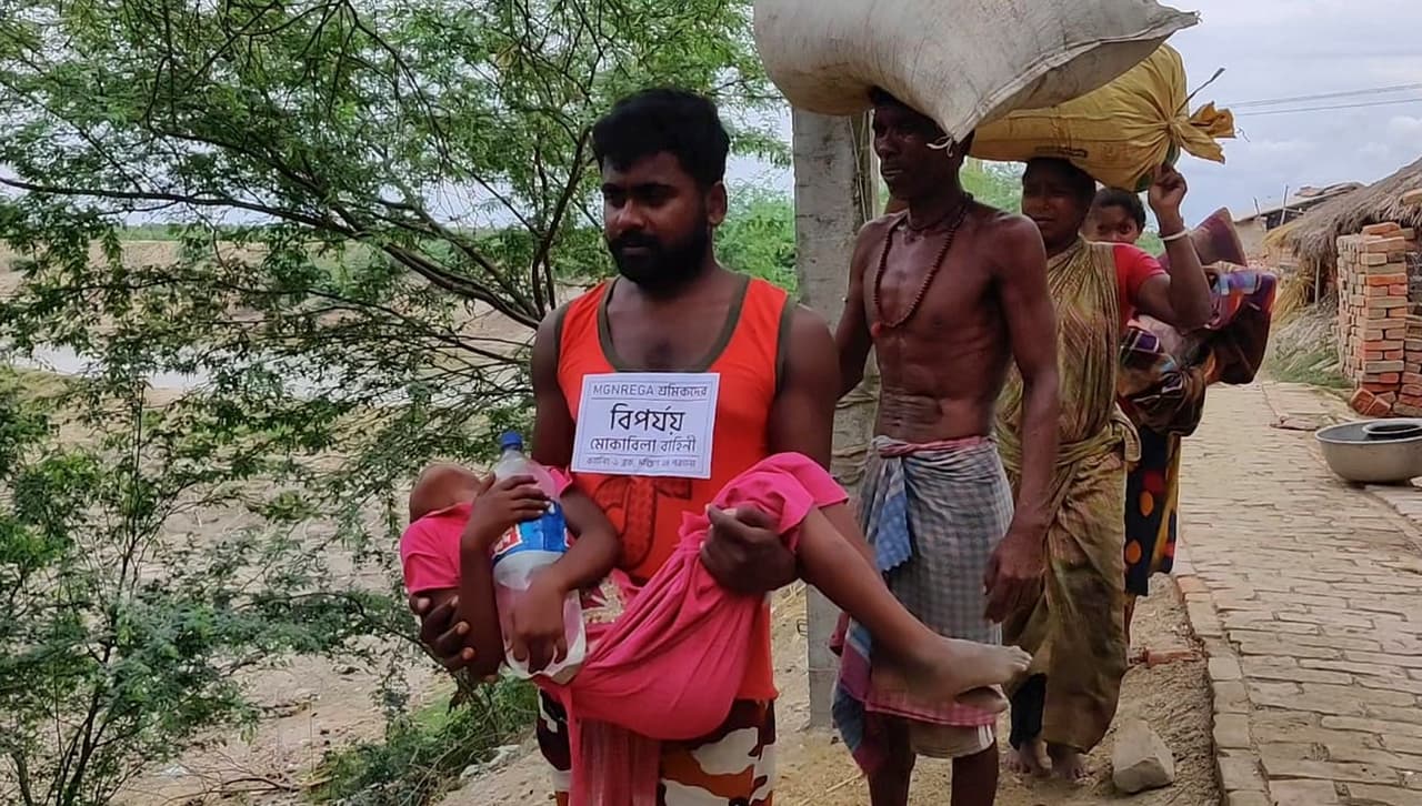 Un voluntario de gestión de desastres lleva a un niño enfermo mientras los aldeanos en la costa de la Bahía de Bengala son evacuados como precaución contra el ciclón Amphan en Bakkhali, South 24 Parganas, Bengala Occidental, India.